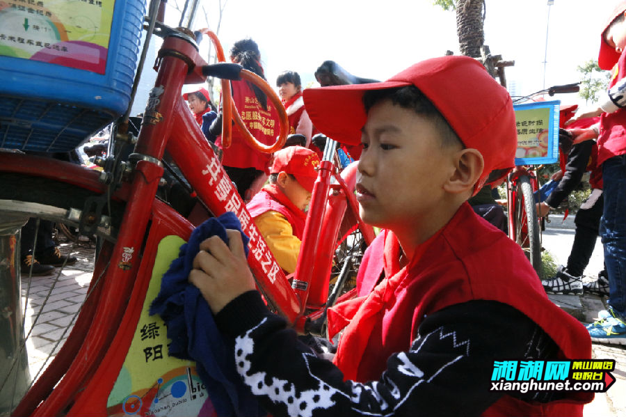 少先队志愿者给公共自行车洗脸